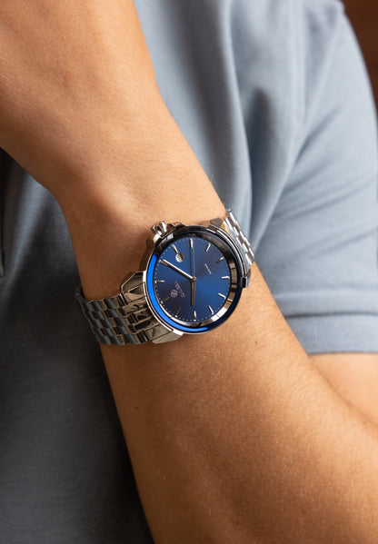 Blue watch  for men - watch with silver strap and blue dial - worn by a men with blue shirt - all swiss made