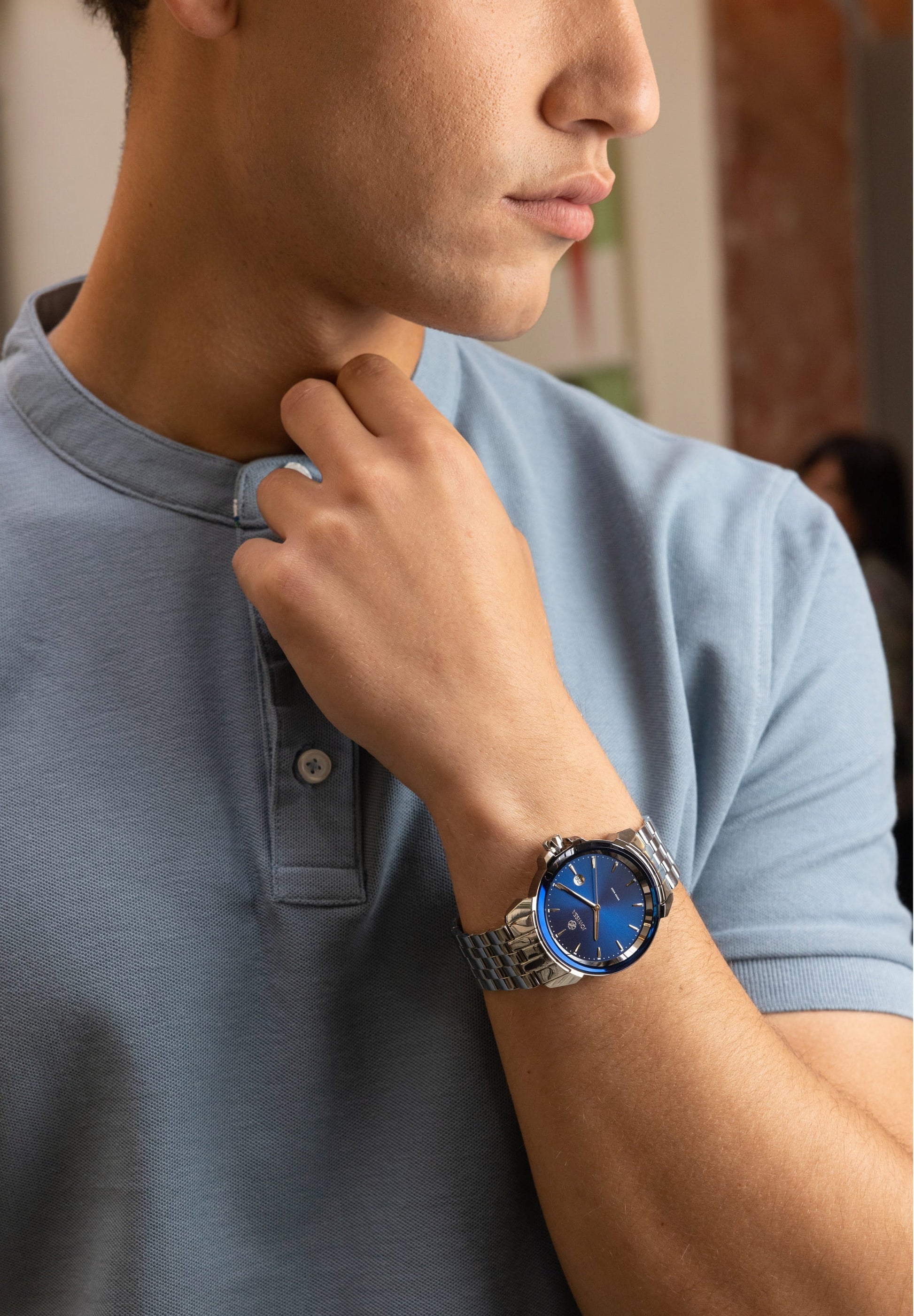 Swiss watch for men with silver strap and blue dial - all swiss made - watch worn by a man with blue shirt